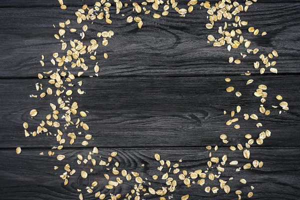 Oatmeal scattered in a circle on a wooden textured background. E — Stock Photo, Image