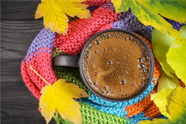 Μαύρος καφές σε μαύρη κούπα τυλιγμένος σε ζεστή, χρωματιστή πλεκτή — Φωτογραφία Αρχείου