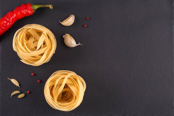 Pâtes Vue de dessus. Fettuccine niche sur un fond gris avec des épices — Photo