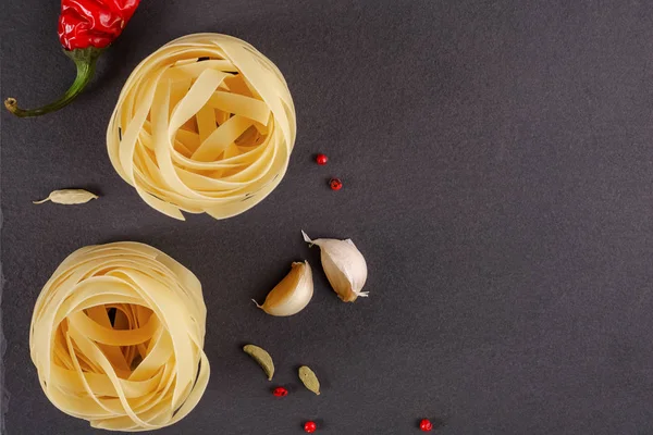 Pâtes Vue de dessus. Fettuccine niche sur un fond gris avec des épices — Photo