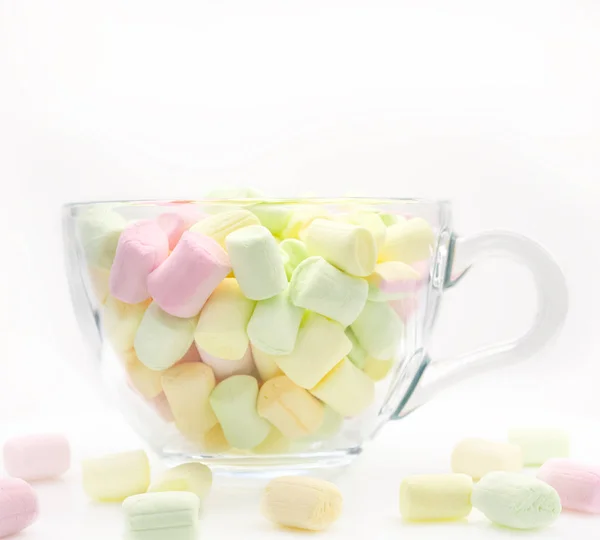 Small multi-colored marshmallows close-up in a transparent, glas