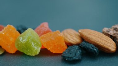 Sağlıklı beslenme konsepti. Granola. Kurutulmuş meyve: fındık, kuru üzüm, kaju, kurutulmuş kayısı, fındık, kabak tohumu. Kameranın sağdan sola hareketi.