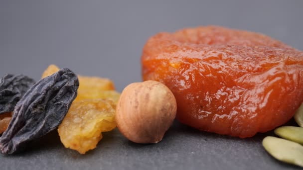 Konzept für gesunde Ernährung. Müsli. Trockenfrüchte: Nüsse, Rosinen, Cashewnüsse, getrocknete Aprikosen, Haselnüsse, Kürbiskerne. Kamerafahrt von links nach rechts. — Stockvideo