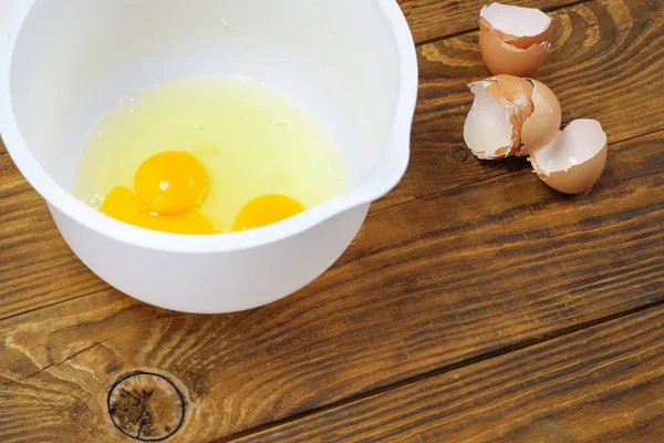 Rozbite jaja w białej misce do wyrobu ciasta. — Zdjęcie stockowe