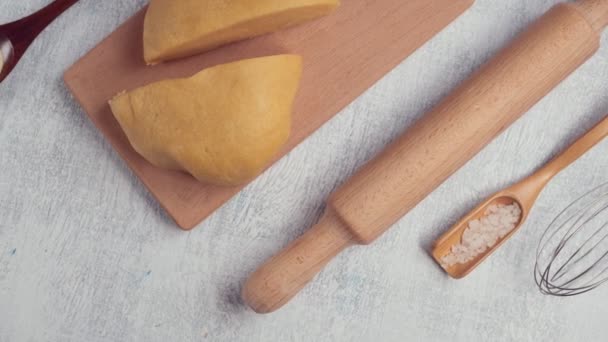 Food background.  Cooking dough : rolling pin, whisk, durum wheat dough, napkin. Food concept. Camera movement top view. — Stock Video