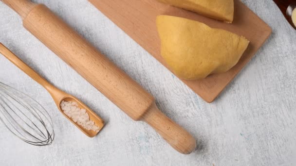 Food background.  Cooking dough : rolling pin, whisk, durum wheat dough, napkin. Food concept. Camera movement top view. — Stock Video