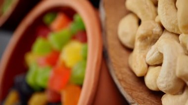 Sağlıklı kahvaltı. Granola. Yulaf ezmesi, arpa gevreği. Fındık: Fındık, badem, kaju. Kuru üzümler, hurmalar, kuru üzümler. Kil kaselerde. Olağandışı bir açı. Daire şeklinde döndür. Yakın çekim, 4k v
