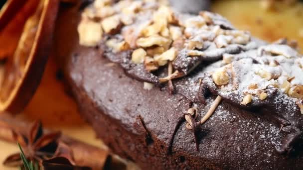 Pastel de Navidad festivo con rodajas de naranja y nueces en el fondo de una guirnalda de Año Nuevo. Movimiento circular — Vídeos de Stock