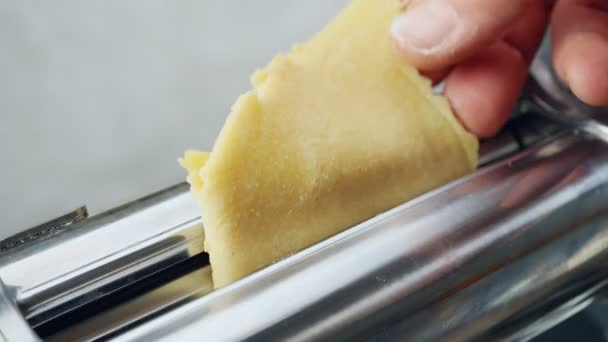 Δύο χέρια κάνουν ζύμη σε μια μηχανή για την παρασκευή λεπτής ζύμης, noodles. — Αρχείο Βίντεο