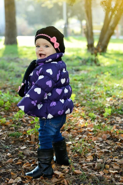 Little girl playing in autumn park — Stock Photo, Image