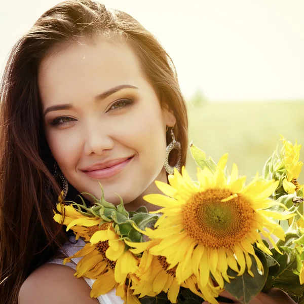 Vrouw bedrijf zonnebloemen — Stockfoto