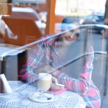 Akıllı telefon kullanan genç bir kadın.