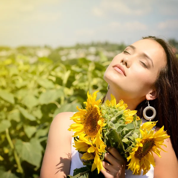 Giovane donna che tiene girasoli — Foto Stock