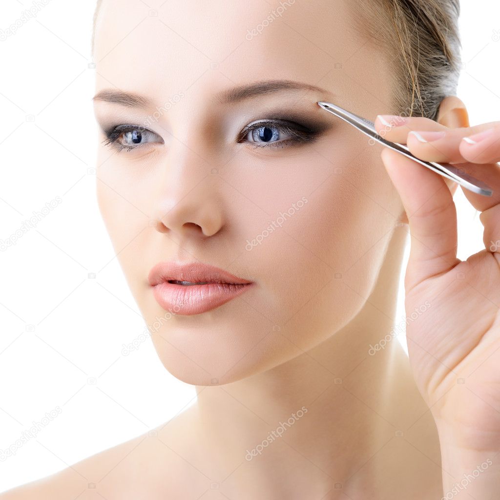 woman plucking eyebrows 