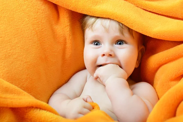 Babyjongen op oranje plaid — Stockfoto