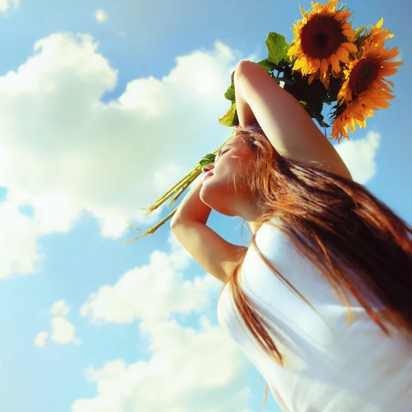 Beautiful woman holding sunflowers — Stock Photo, Image