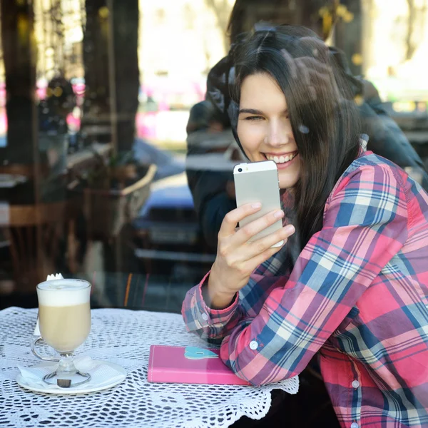 Kobieta za pomocą smartfona w kawiarni — Zdjęcie stockowe