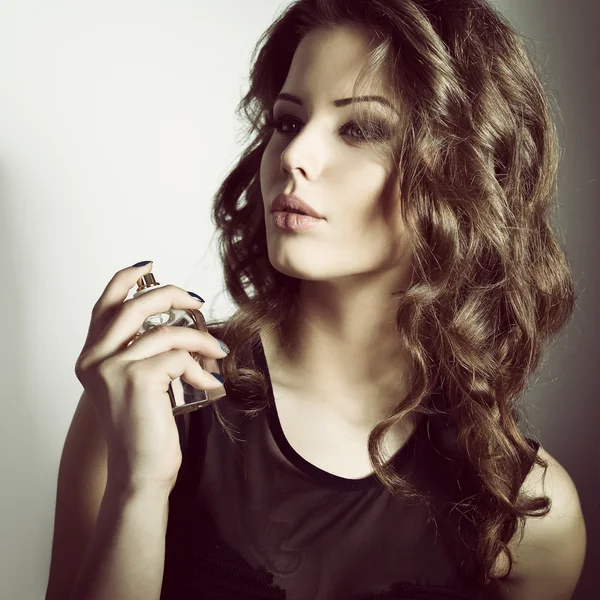 Young woman holding perfume — Stock Photo, Image