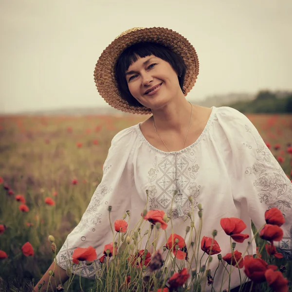 Mulher tem diversão no campo de papoula — Fotografia de Stock