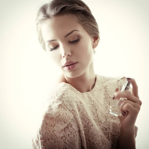 Bela senhora segurando perfume — Fotografia de Stock