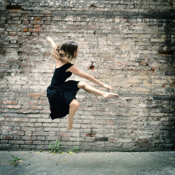 Девушка в чёрном платье танцует — стоковое фото