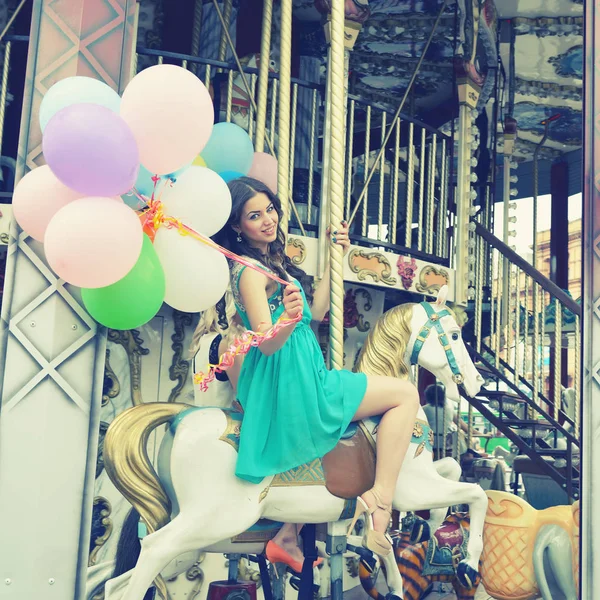 Vrouw met ballonnen op carrousel — Stockfoto