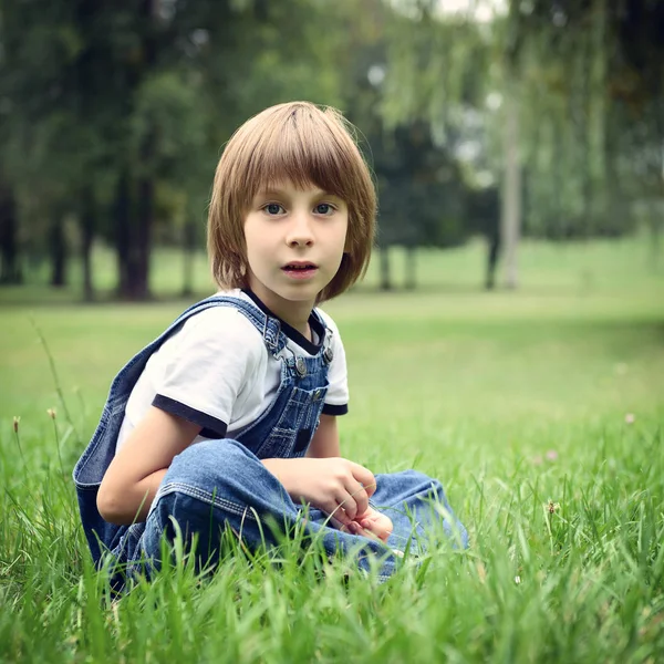 Schattige jongen in gras — Stockfoto