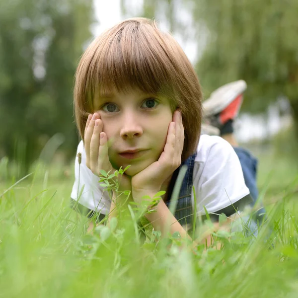 Schattige jongen in gras — Stockfoto