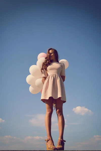 Kvinna med ballonger i blå himmel — Stockfoto
