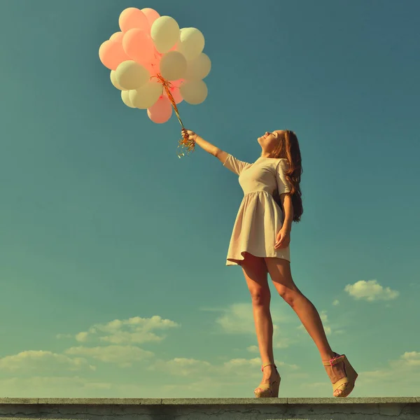 Mujer con globos en el cielo azul — Foto de Stock