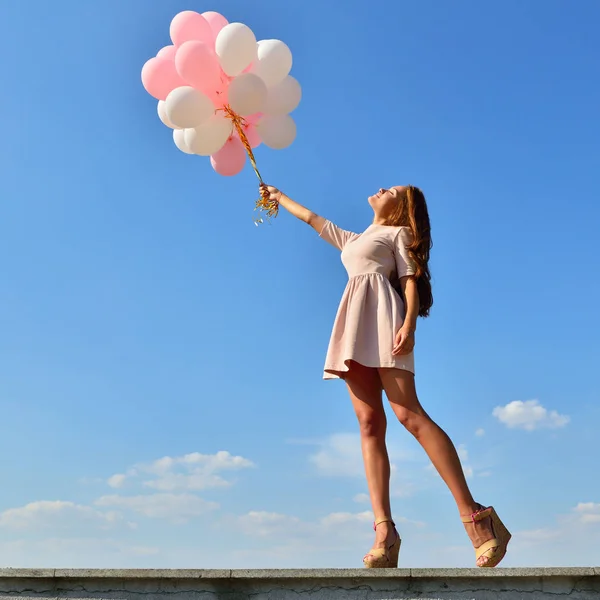 Woman with balloons in sky — Stock Photo, Image