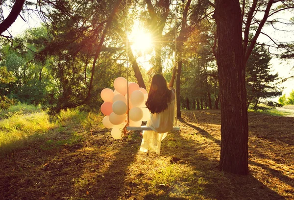 Женщина с воздушными шарами в лесу — стоковое фото