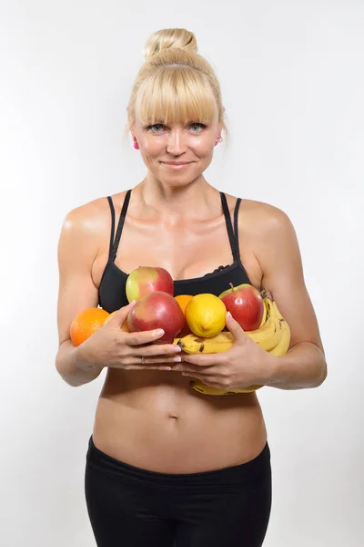 Mujer atlética sosteniendo fruta — Foto de Stock