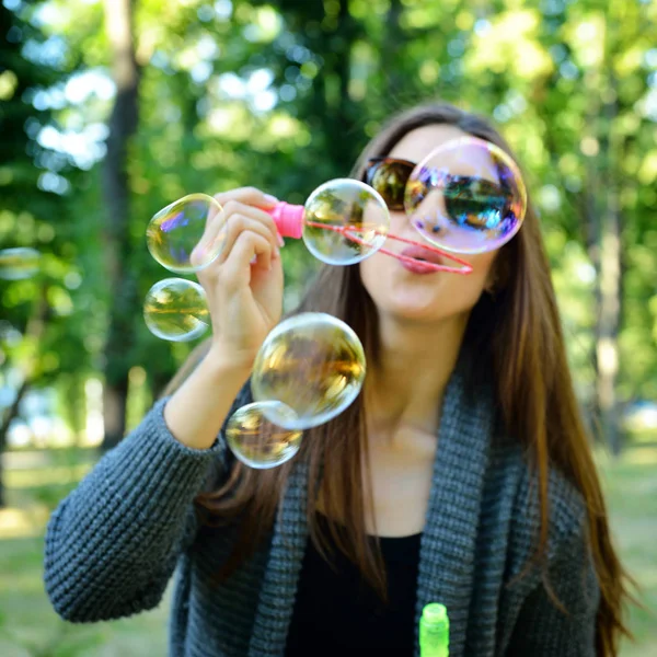 Femme soufflant des bulles de savon — Photo