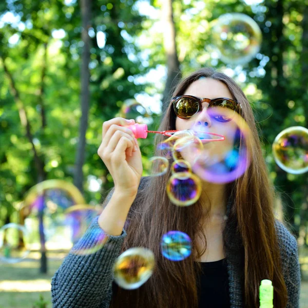 Mujer soplando burbujas en el parque —  Fotos de Stock