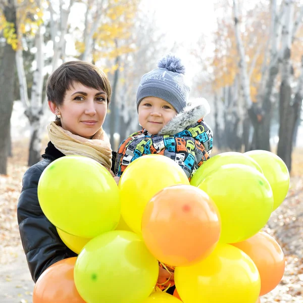 Mor innehav son och ballonger — Stockfoto