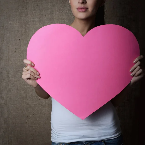 Жінка тримає рожеве серце — стокове фото
