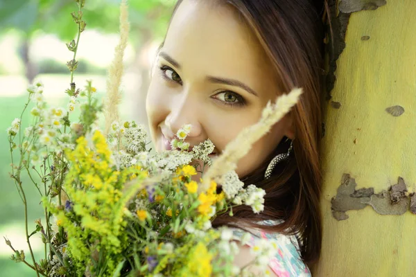 Woman holding wild flowers — Stock Photo, Image