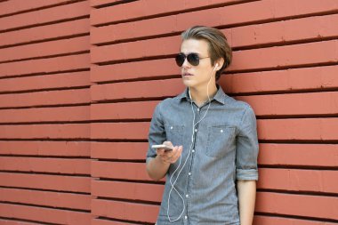 Genç adam akıllı telefon kullanıyor.