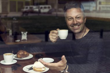 Yakışıklı adam kahve içiyor.