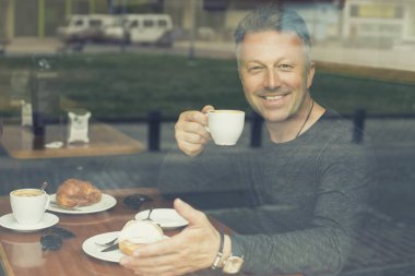 Adam sabah kahvesini içiyor.