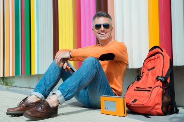 renkli duvara yakın oturan adam