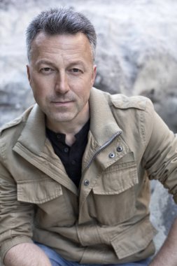 Kayalar üzerine oturan yakışıklı adam