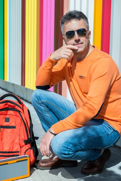 Muž sedící poblíž barevné zdi — Stock fotografie