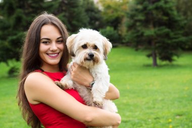 Kızla köpek yavrusu. Çekici mutlu gülümseyen genç kadını portresi