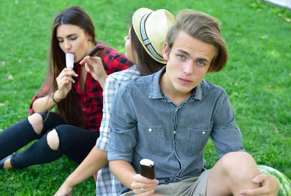 Jeune homme et femmes mangeant de la glace au chocolat en plein air en été — Photo