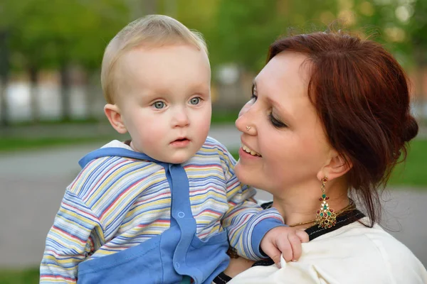 Feliz madre sosteniendo a su adorable hijito. Familia lei al aire libre —  Fotos de Stock