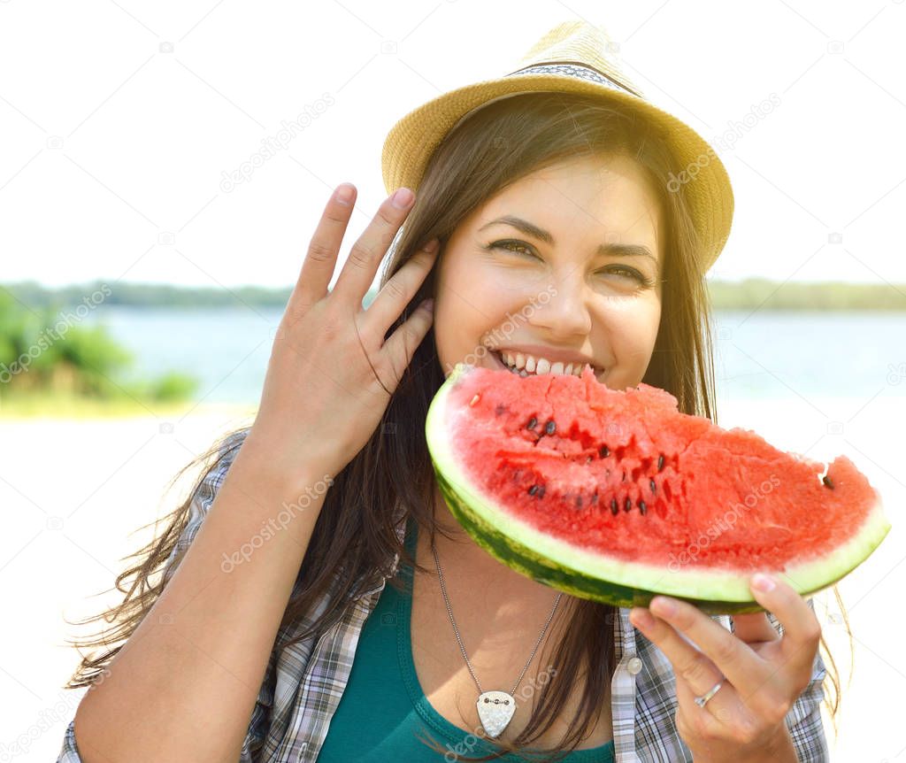 Happy young couple eating watermelon on the beach. Youth lifesty