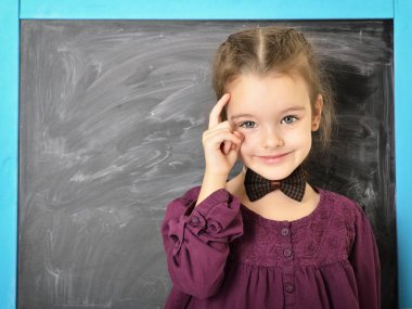 Şirin liitle kız Blackboard ve mutlu gülümseyerek ayakta. Bea