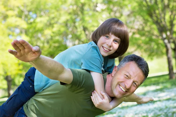 Retrato del padre con su hijo divirtiéndose en el parque de verano. Cerdito. — Foto de Stock